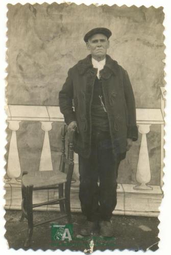 Hombre mayor apoyado en silla